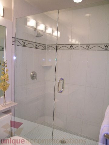 Spacious bathroom with glass shower, modern fixtures, and white tiles. - 3802 - 1189 Melville Street, Vancouver Downtown
