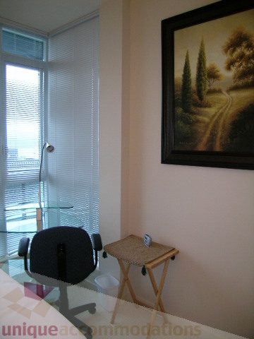 Furnished living room with a small stool, glass table, and a scenic painting. - 3802 - 1189 Melville Street, Vancouver Downtown