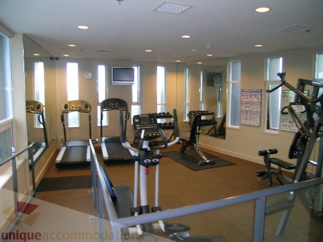 Furnished gym with treadmills, mirrors, and exercise equipment. - 3802 - 1189 Melville Street, Vancouver Downtown