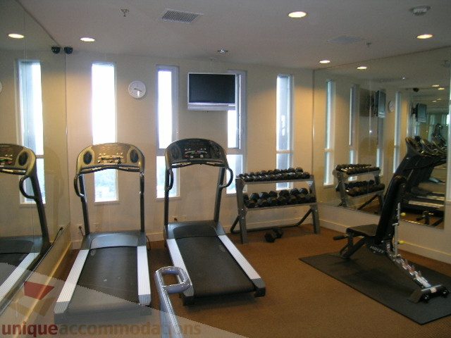 Furnished gym with treadmills, mirrors, and weight machines. - 3802 - 1189 Melville Street, Vancouver Downtown