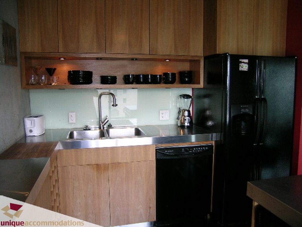Modern kitchen with wooden cabinets, stainless steel countertops, and black appliances. - 705 - 1500 Howe street, Vancouver Downtown