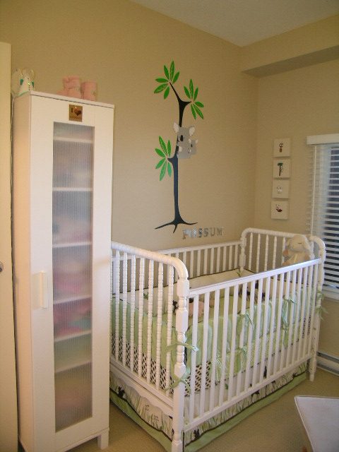 Bright nursery with white crib and green tree decal on wall. - 315 - 4078 Knight Street, Vancouver West Side