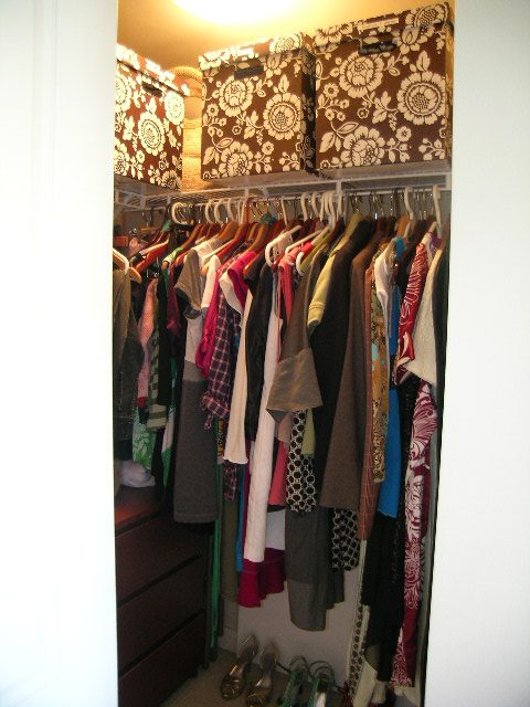 Closet with neatly organized clothes and floral-patterned storage boxes. - 315 - 4078 Knight Street, Vancouver West Side