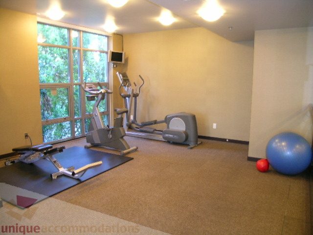 Fitness room with cardio machines, exercise balls, and a large window view. - 2401 - 1005 Beach Avenue, Vancouver Downtown