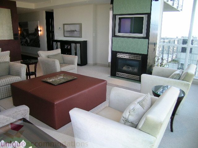 Furnished living room with modern furniture, fireplace, and city view. - 4303 - 1408 Strathmore Mews, Vancouver Downtown