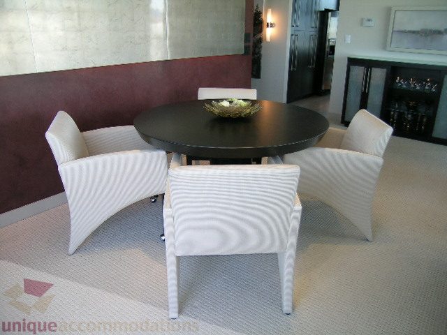 Bright dining area with modern black table and white chairs, clean lines and contemporary decor. - 4303 - 1408 Strathmore Mews, Vancouver Downtown