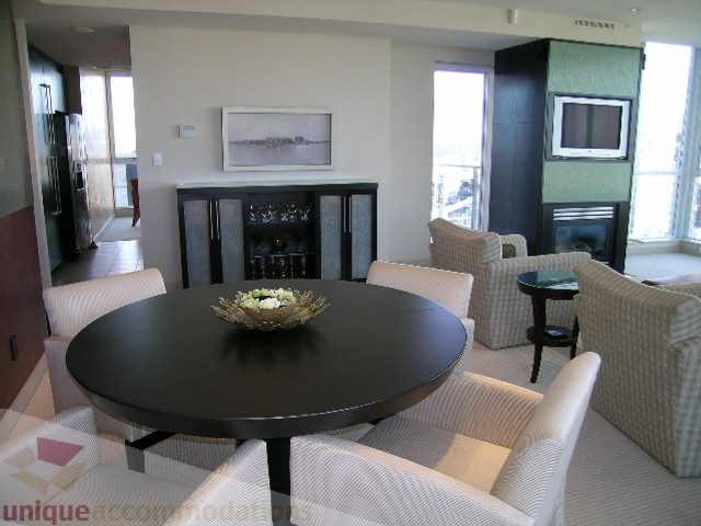 Bright dining area with round table, modern decor, and city view. - 4303 - 1408 Strathmore Mews, Vancouver Downtown