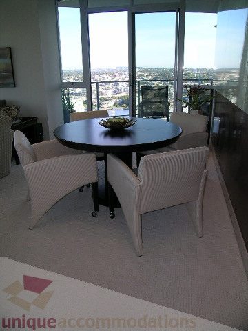 Furnished dining area with a round table, city view, and modern chairs. - 4303 - 1408 Strathmore Mews, Vancouver Downtown