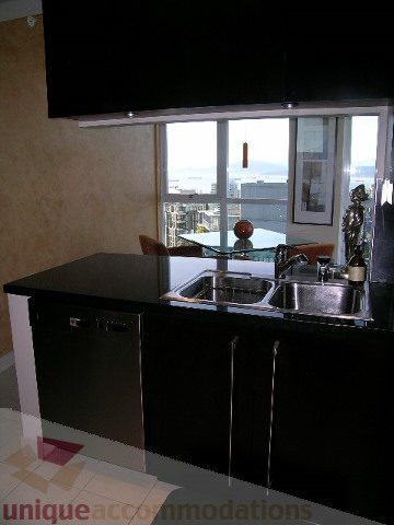 Bright kitchen with black countertops and city view. - 4303 - 1408 Strathmore Mews, Vancouver Downtown