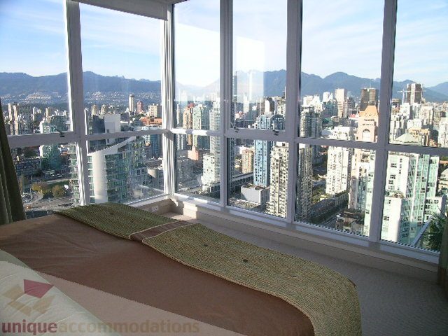 Bright bedroom with a stunning city view, featuring a large window and a comfortable bed. - 4303 - 1408 Strathmore Mews, Vancouver Downtown