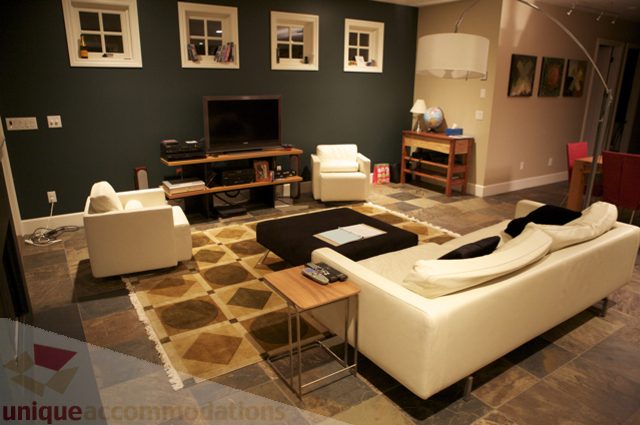 Furnished living room with geometric rug, modern furniture, and dark walls. - 3781 Bayridge Ave, West Vancouver