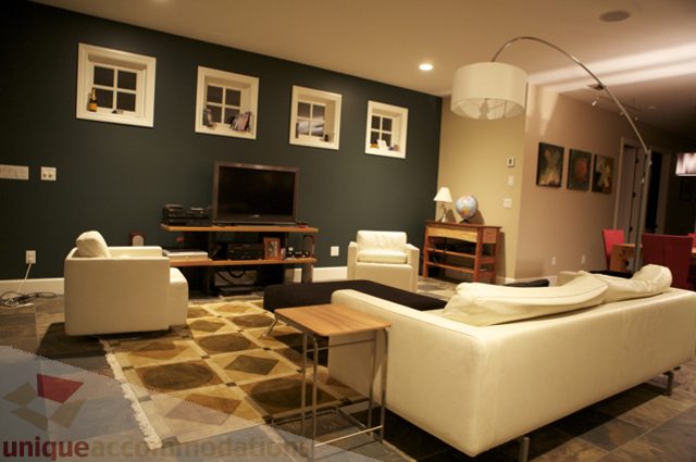 Furnished living room with white couches, dark green walls, and a wooden coffee table. - 3781 Bayridge Ave, West Vancouver