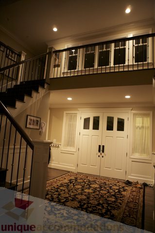 Staircase leading to upper level with black railings and white trim. - 3781 Bayridge Ave, West Vancouver