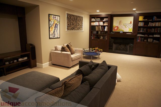 Spacious living room with bookshelves, fireplace, and comfortable seating. - 3781 Bayridge Ave, West Vancouver