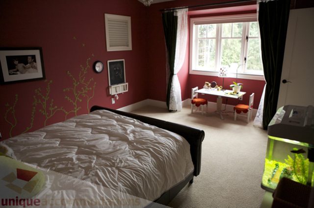 Bright bedroom with red walls, white furniture, and a small desk. - 3781 Bayridge Ave, West Vancouver