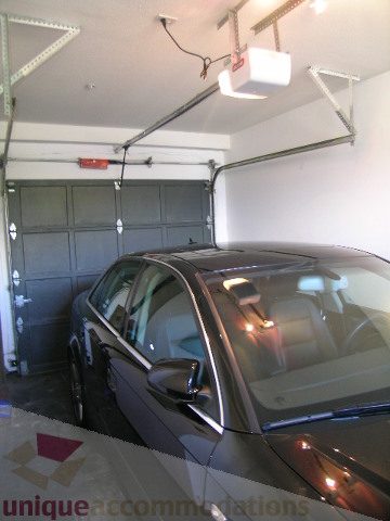 Garage with open door, car parked inside, overhead light fixture. - 137 Alexander Street, Vancouver Downtown