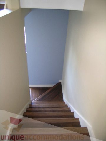 Staircase leading to upper level with wooden steps and white walls. - 137 Alexander Street, Vancouver Downtown