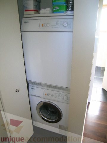 Bright laundry room with white washer and dryer, hardwood floors. - 137 Alexander Street, Vancouver Downtown