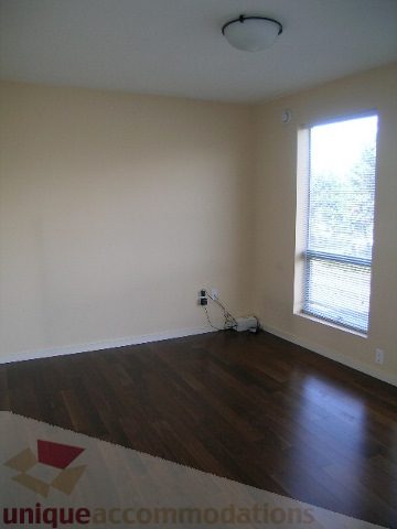 Bright living room with hardwood floors and large window view. - 137 Alexander Street, Vancouver Downtown