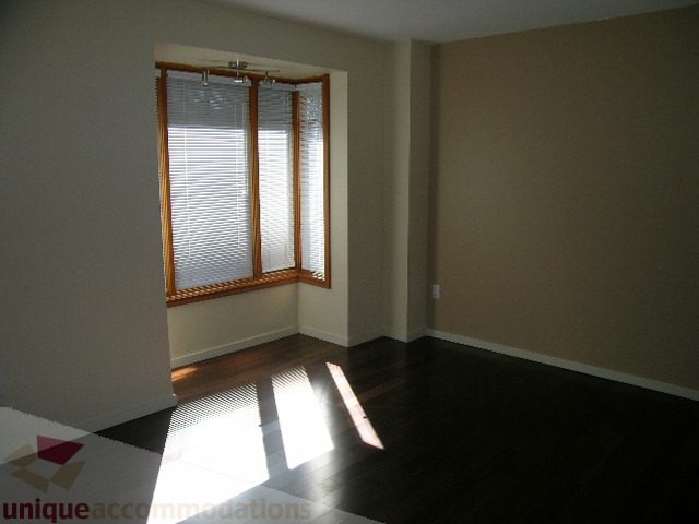 Bright living room with hardwood floors and large window with blinds. - 137 Alexander Street, Vancouver Downtown