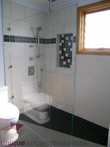 Bright bathroom with glass shower, black and white mosaic tiles, and natural light from window. - 137 Alexander Street, Vancouver Downtown