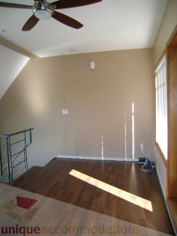 Bright living room with hardwood floors and a ceiling fan. - 137 Alexander Street, Vancouver Downtown