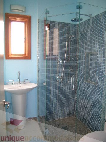 Bright bathroom with blue mosaic tiles and a glass shower enclosure. - 137 Alexander Street, Vancouver Downtown