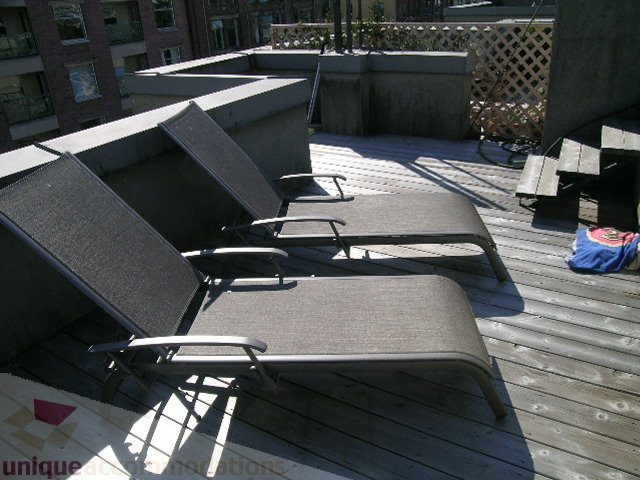 Furnished rooftop deck with lounge chairs and city view. - 137 Alexander Street, Vancouver Downtown