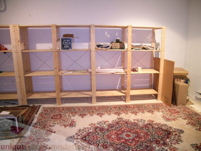 Bright living room with wooden shelving and patterned rug. - 137 Alexander Street, Vancouver Downtown