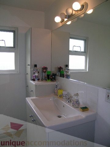 Bright bathroom with white countertops and a large mirror. - 4408 Arbutus Street, Vancouver West Side