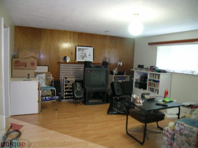 Living room with hardwood floors, a fireplace, and a desk setup. - 4408 Arbutus Street, Vancouver West Side