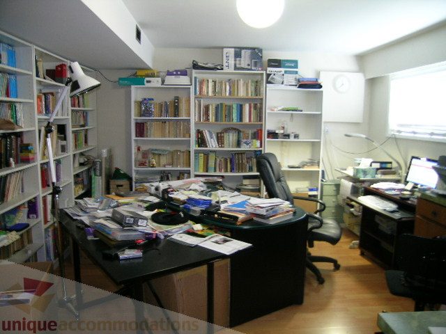 Furnished office with cluttered desk, bookshelves, and hardwood floors. - 4408 Arbutus Street, Vancouver West Side