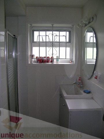 Bright bathroom with white tiles, large window, and modern sink. - 4408 Arbutus Street, Vancouver West Side