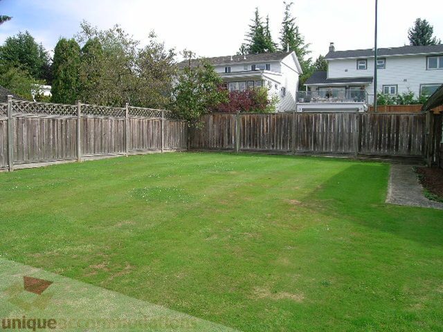 Lush green backyard with wooden fence and house in background. - 4408 Arbutus Street, Vancouver West Side