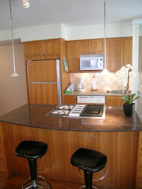 Bright kitchen with granite countertops, wooden cabinets, and black bar stools. - 1102 - 1723 Alberni Street, Vancouver Downtown