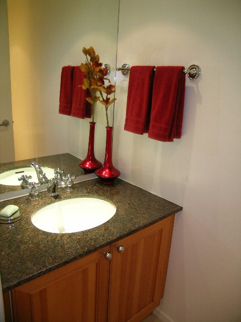 Bathroom with granite countertops, red towels, and a vase of flowers. - 1102 - 1723 Alberni Street, Vancouver Downtown