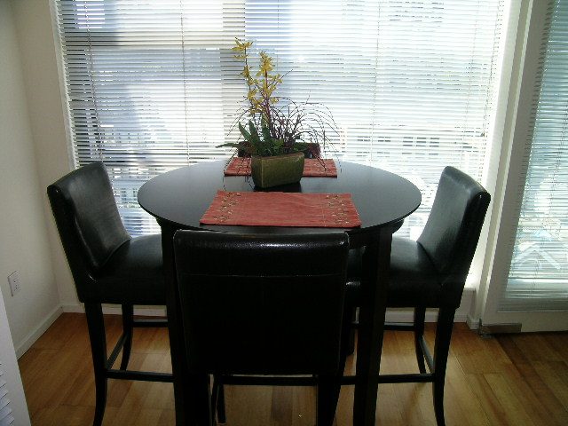 Bright dining area with black chairs, round table, and hardwood floors. - 1102 - 1723 Alberni Street, Vancouver Downtown