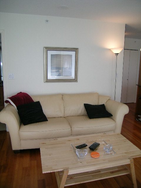 Bright living room with white leather couch, wooden coffee table, and floor lamp. - 1102 - 1723 Alberni Street, Vancouver Downtown