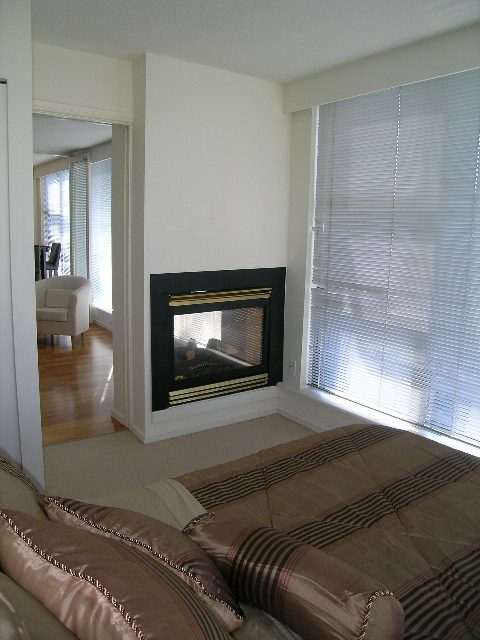 Bright living room with fireplace, hardwood floors, and large windows. - 1102 - 1723 Alberni Street, Vancouver Downtown