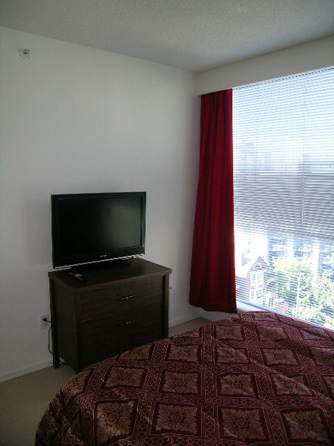 Bright bedroom with red curtains and city view. - 1102 - 1723 Alberni Street, Vancouver Downtown