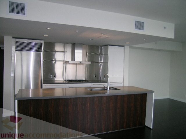 Bright kitchen with stainless steel appliances and dark wood countertops. - 2804-788 Richards Street, Vancouver Downtown