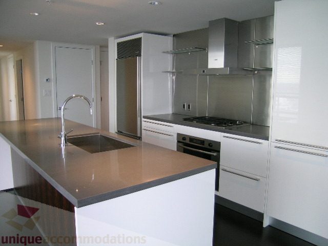 Bright kitchen with modern white cabinetry, stainless steel appliances, and granite countertops. - 2804-788 Richards Street, Vancouver Downtown