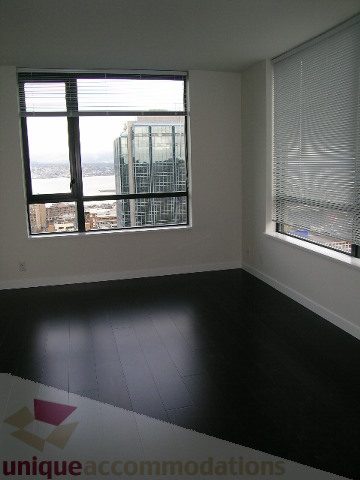 Spacious living room with hardwood floors and a city view. - 2804-788 Richards Street, Vancouver Downtown