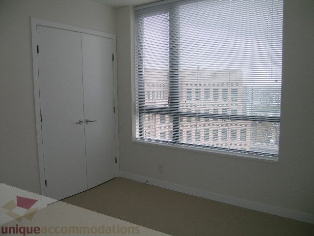 Bright living room with city view and blinds covering large windows. - 2804-788 Richards Street, Vancouver Downtown