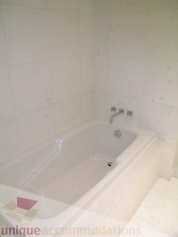 Bathroom with white tiles and a bathtub. - 2804-788 Richards Street, Vancouver Downtown