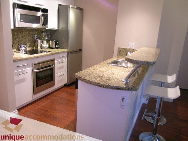 Modern kitchen with granite countertops, stainless steel appliances, and hardwood floors. - 1205 - 1331 West Georgia Street, Vancouver Downtown
