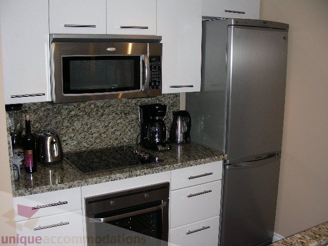 Bright kitchen with granite countertops, stainless steel appliances, and modern cabinetry. - 1205 - 1331 West Georgia Street, Vancouver Downtown