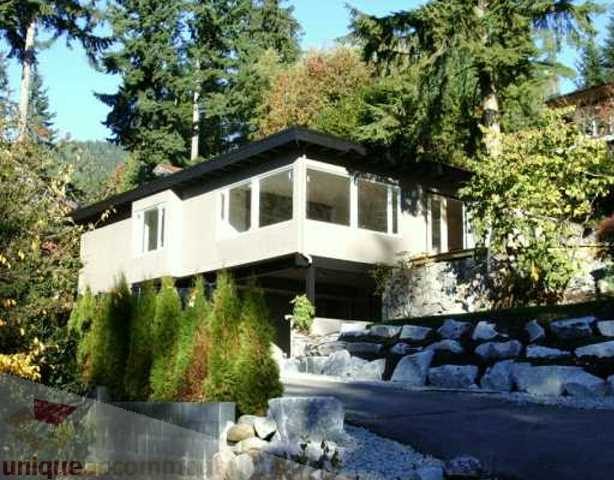 Furnished 3-bedroom suite with large windows and a deck, surrounded by trees. - 250 Rockland Road West, North Vancouver