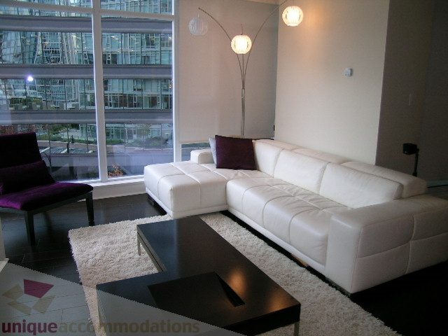 Bright living room with white leather sofa, city view, and modern decor. - 604 - 1205 West Hastings Street, Vancouver Downtown