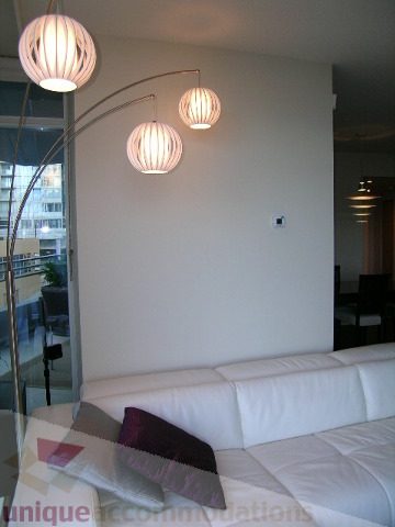 Bright living room with modern lighting and white leather sofa, city view. - 604 - 1205 West Hastings Street, Vancouver Downtown
